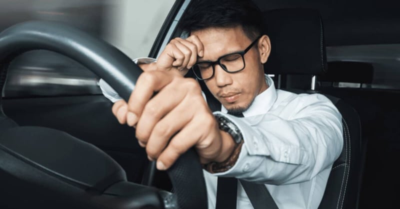 Picture of someone driving with a headache
